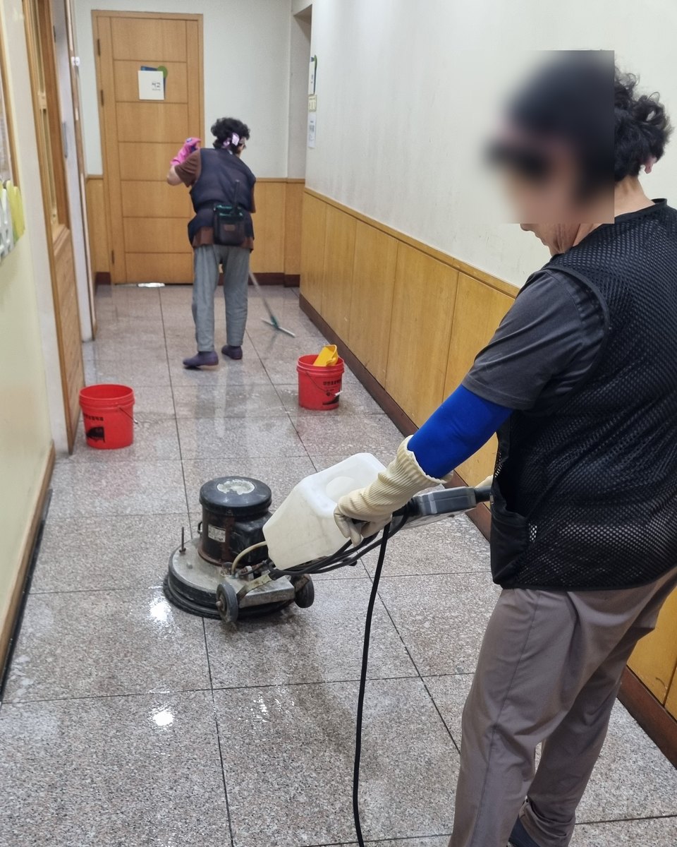 복도 바닥을 기계로 세척하는 직원들